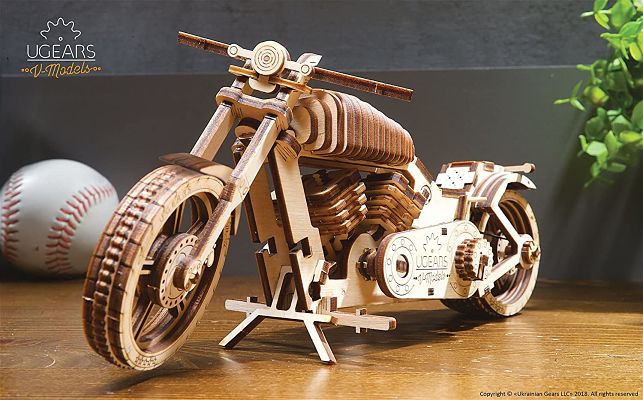 Detailed 3D wooden puzzle of a motorcycle with visible gears, layered wood texture, and a kickstand on a wooden surface.