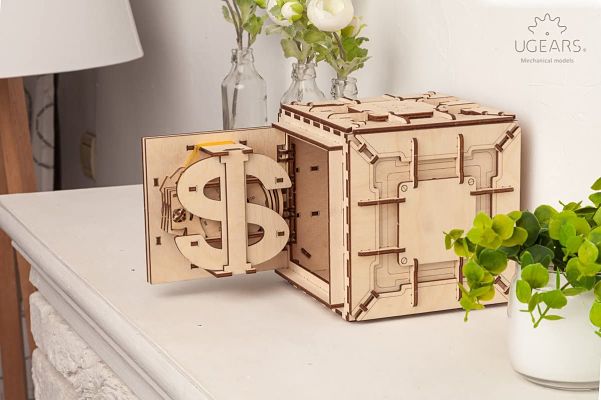 Laser-cut wooden safe puzzle with an open door, large dollar sign dial, and intricate mechanical gears.