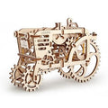 Intricate light-wood 3D mechanical tractor puzzle featuring large gear wheels and visible inner clockwork mechanisms.