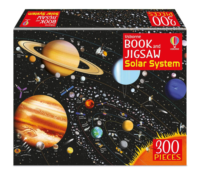 Solar system jigsaw box showing colorful planets and space probes on a black background with a red 300 pieces label.