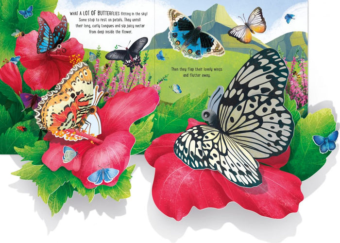 Open pop-up book showing vibrant 3D illustrations of butterflies on red flowers against a mountain landscape.