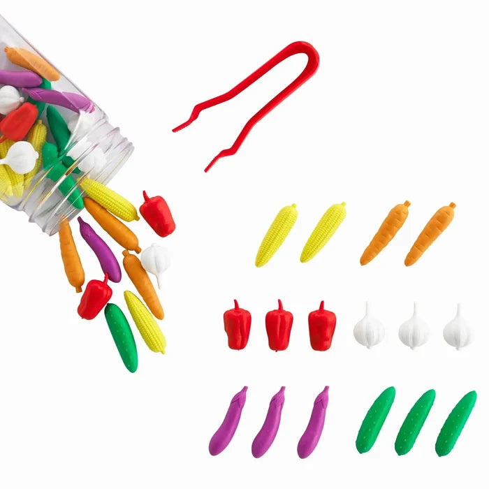 Colorful plastic vegetable counters spilling from a jar next to red tweezers and sorted rows on a white background.