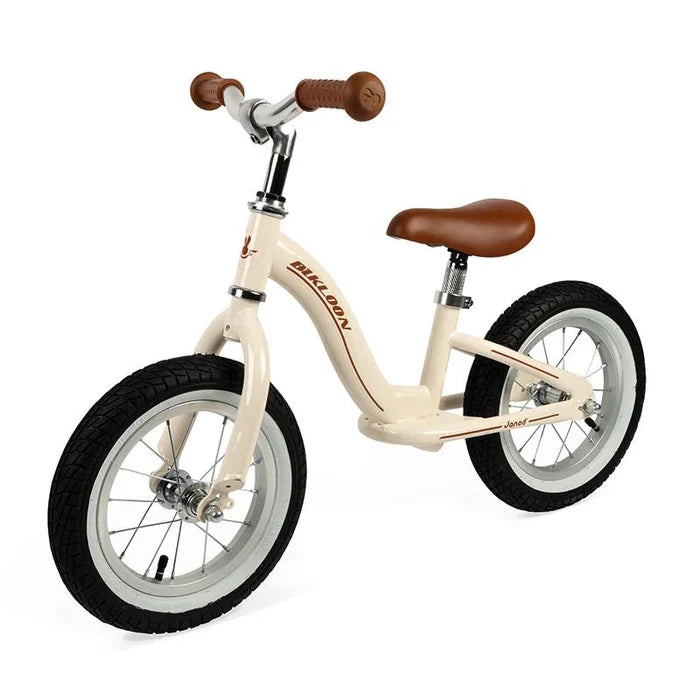 Beige vintage-style balance bike with brown seat and handlebars, featuring white rims and black rubber tires.