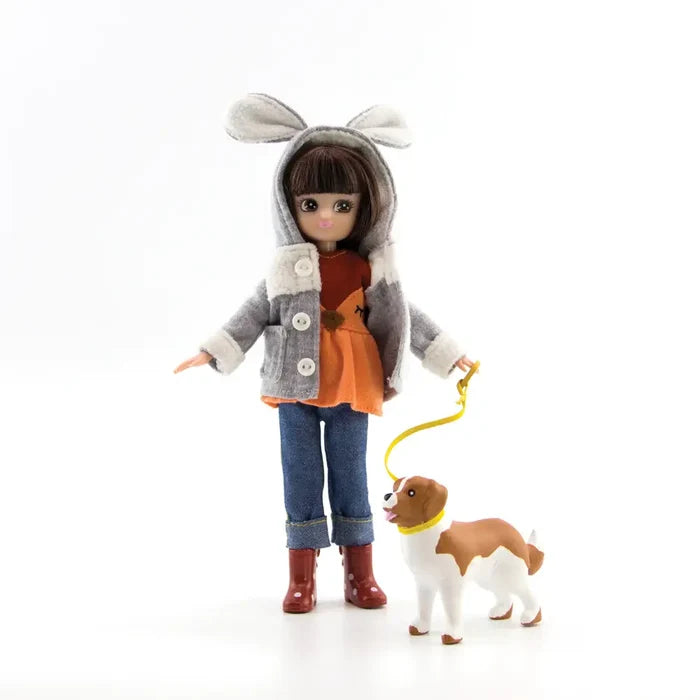 Doll in a grey bunny-ear hoodie, jeans, and red boots walking a brown and white toy dog on a yellow leash.
