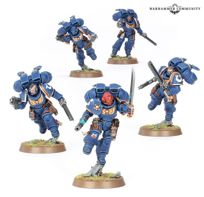 Five blue Space Marine miniatures with jump packs and gold trim, wielding swords and pistols in dynamic action poses.