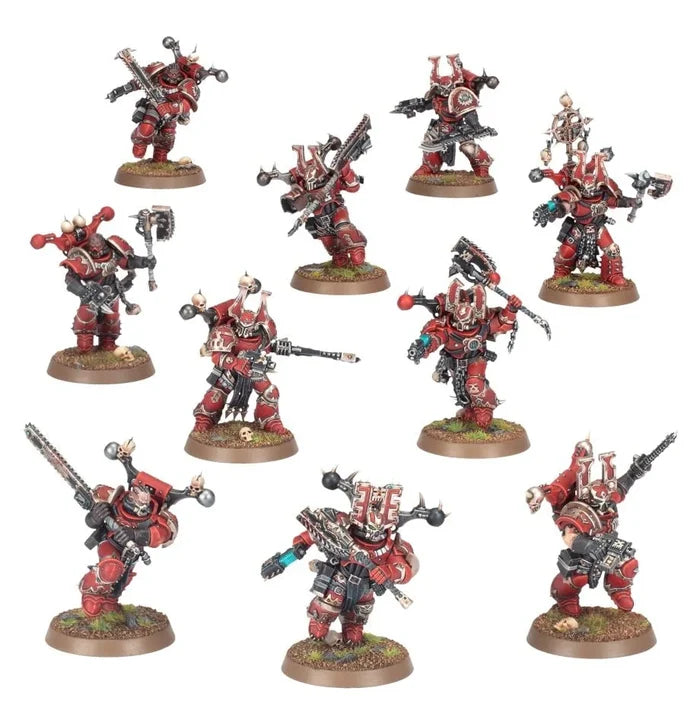 Ten miniatures in red and brass power armor with chainaxes and ornate helmets in dynamic poses on grassy bases.