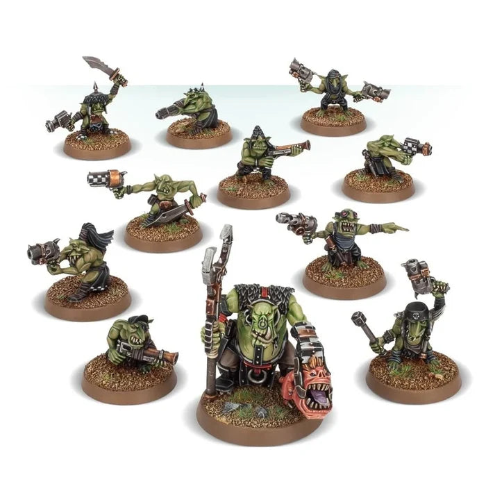 Twelve painted green Ork miniatures with scrap guns, checkered armor, and a red squig on textured circular bases.
