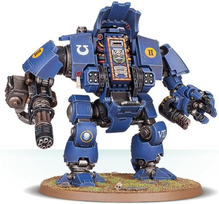 Heavily armored blue bipedal combat walker with a rotary cannon and mechanical claw on a circular grass base.