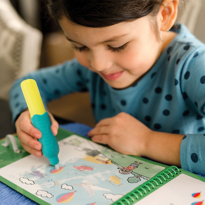 Child using a chunky blue and yellow water pen on a vehicle-themed spiral activity book to reveal colorful art.