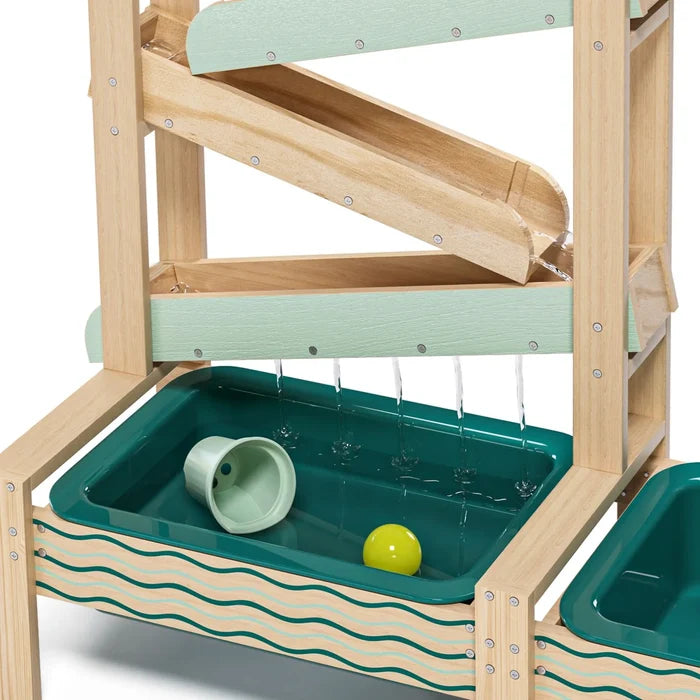 Wooden tiered water station with mint green tracks dripping water into a teal tray with a yellow ball and small cup.