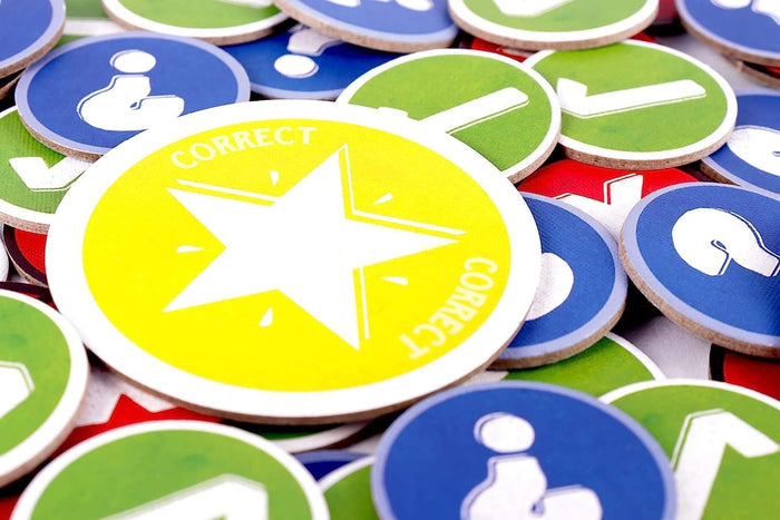 Colorful round cardboard tokens with blue question marks, green checkmarks, and a bright yellow star labeled CORRECT.