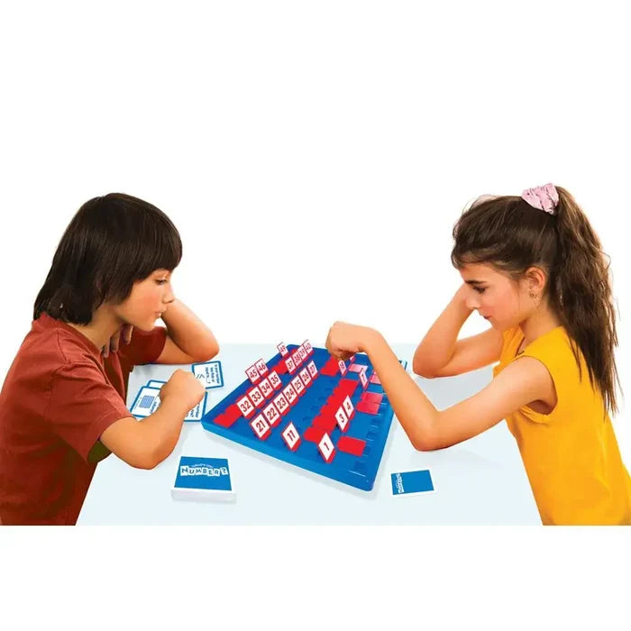 Two children play a blue number guessing game with red flip-up tiles and cards on a white table.