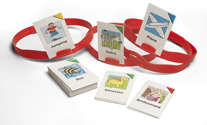 Three red plastic headbands holding illustrated word cards, with extra cards and a deck on a white surface.