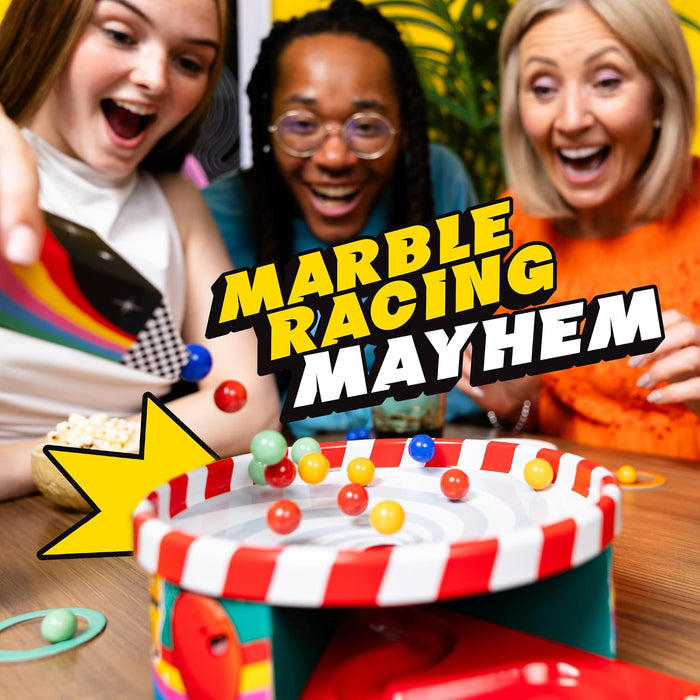 Three people cheer as colorful marbles spin in a red and white striped circular tabletop racing game.