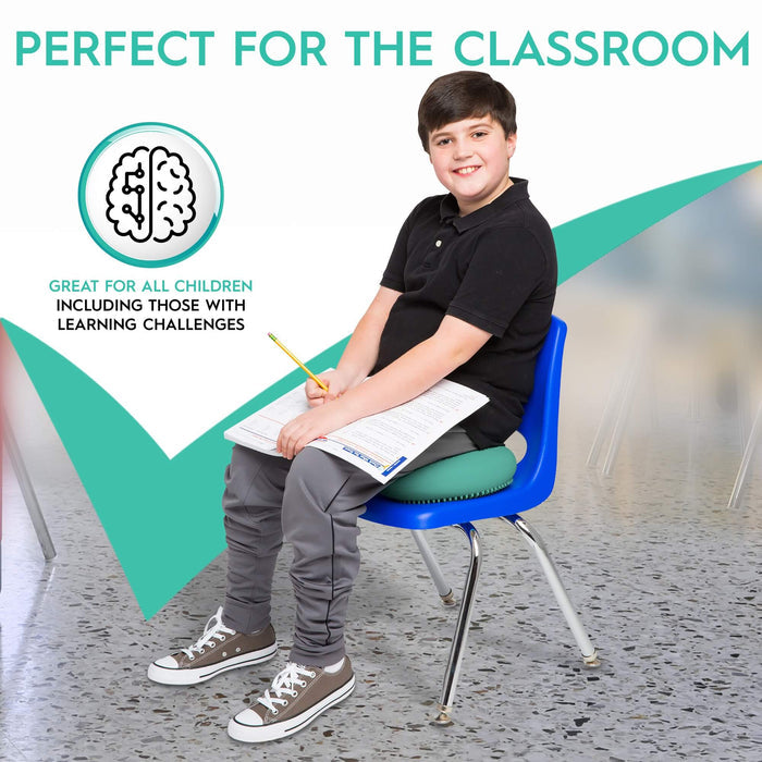 A boy sits on a blue classroom chair using a round, green textured sensory cushion.
