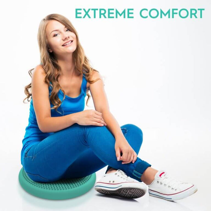 Woman sitting on a round green sensory disc with a textured, bumpy surface for extreme comfort.
