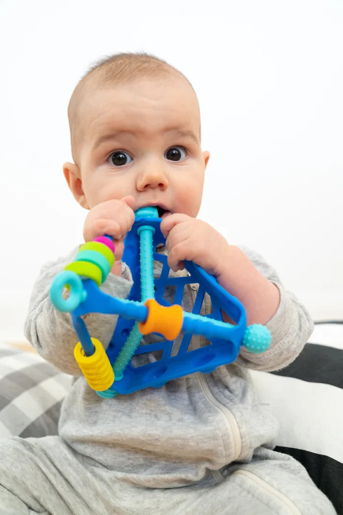 Baby chewing on a blue triangular toy with colorful sliding beads and textured bars.