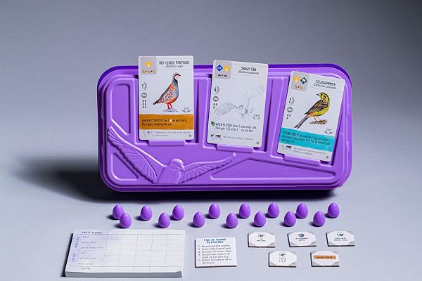 Purple tray holding three bird cards, 15 purple miniature eggs, score pad, and cardboard tokens on a light background.