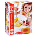 Hape box shows a child playing with a white wooden toaster, red dial, toy bread, butter, honey, and a wooden knife.