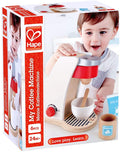 Hape wooden toy coffee machine packaging featuring a white and red machine, cup, spoon, and a toddler playing.