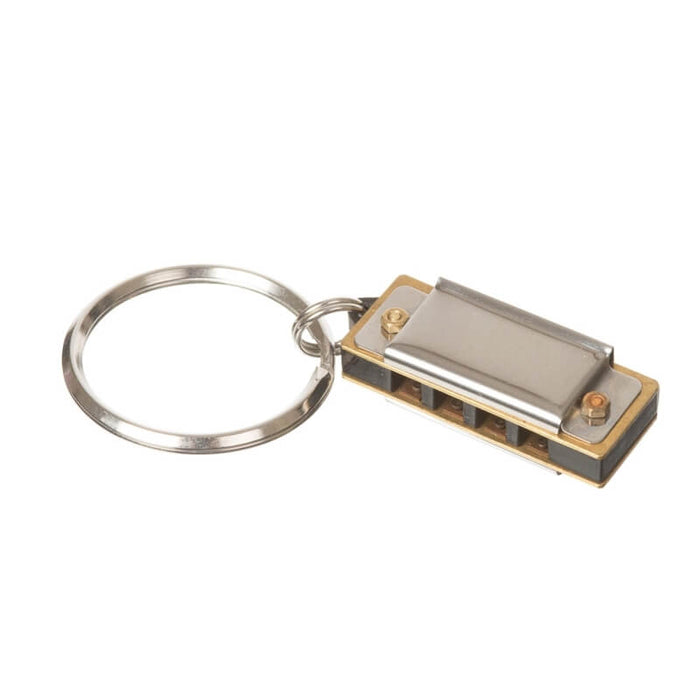Miniature silver and gold metal harmonica with four holes attached to a circular silver keyring.