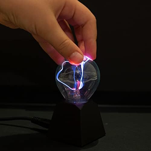 Fingertip touching a mini glass plasma ball with glowing blue and pink electrical arcs on a black pedestal base.